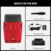 Box contents graphic for a BaBylissPRO red and black cordless shaver, showing the shaver, cleaning brush, charging cable, charger, and charging stand with the heading 'WHAT'S IN THE BOX'.