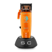 An orange and black Saber II pet clipper standing on a black charging dock against a white background.