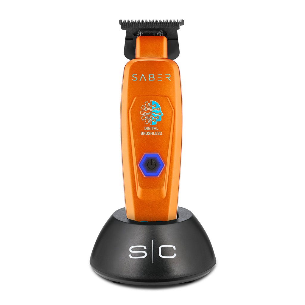 An orange SABER digital brushless electric trimmer standing upright on a black charging base against a white background.